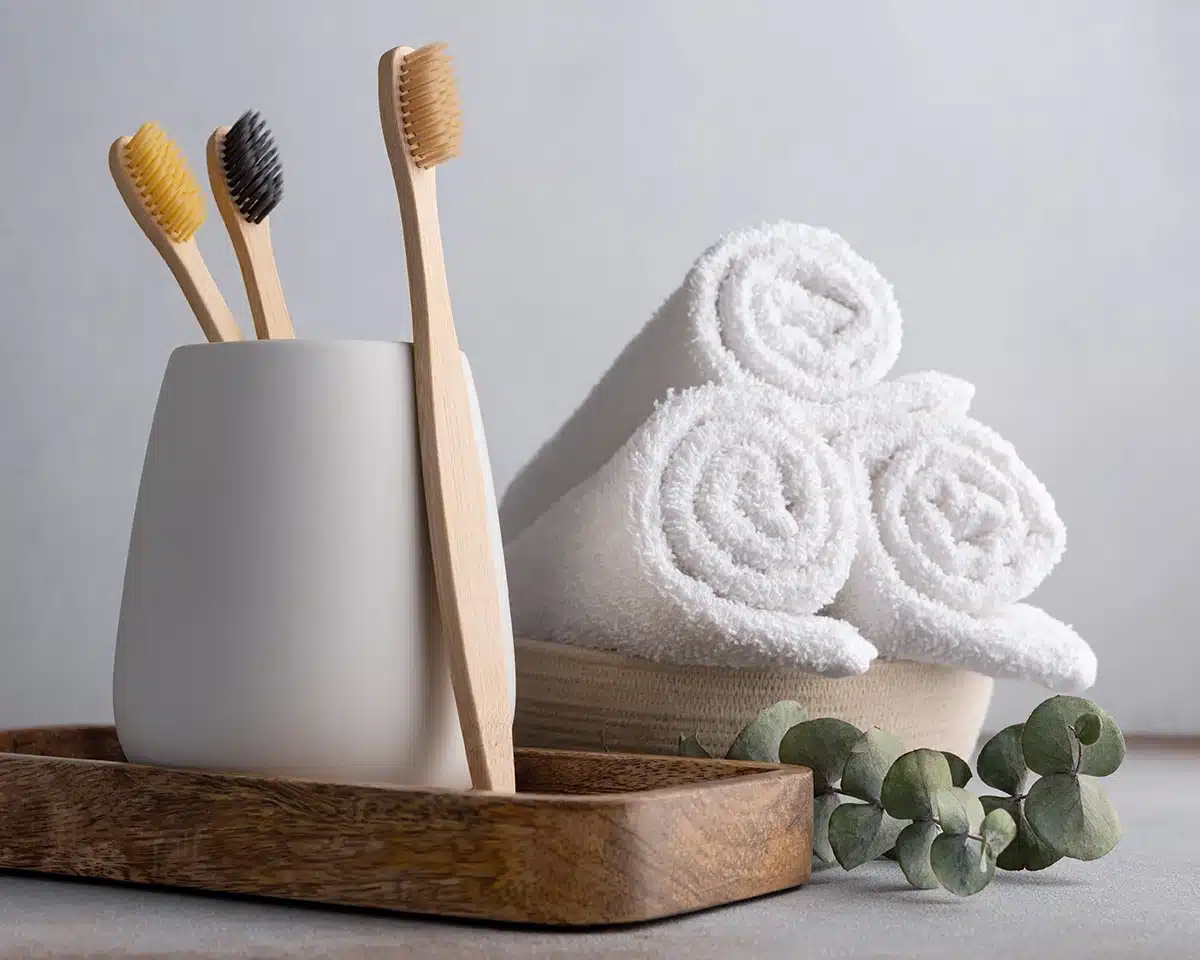 Toothbrushes and dental floss in a ceramic cup Stylised photo of manual toothbrushes in a minimalist bathroom cup on a wooden shelf
